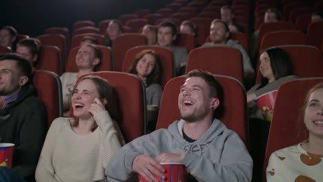 Jóvenes-se-ríen-de-la-película-de-comedia-en-cine-teatro.-Gente-riendo-en-el-cine