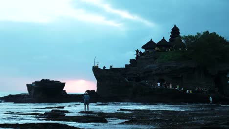 un-hombre-ve-la-puesta-del-sol-en-tanah-lot-en-bali-durante-la-marea-baja