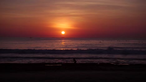 Leuchtend-bunte-Sonnenuntergang-oder-Sonnenaufgang-und-Meer-mit-Wellen-am-tropischen-Strand