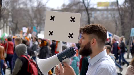 Europäische-Menschen-bei-Demonstration.-Mann-mit-einem-Banner-schreien-in-ein-Mundstück.