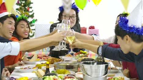 Gruppe-von-Asiaten-zusammen-am-Tisch-Toasten-und-Weihnachten-mit-leckeren-Essen-an-Silvester-Party-zu-feiern.-Menschen-mit-Urlaub-und-Feier-Konzept.