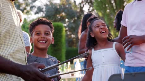 Kinder-reden-und-Lachen-mit-ihrer-Familie-beim-Grillen