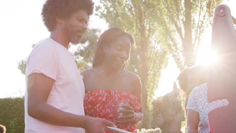 Couple-talking-at-multi-generation-family-barbecue