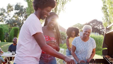 Middle-aged-father-grilling-at-a-barbecue-with-his-family