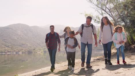 Familia-de-multi-generación-senderismo-por-un-lago-de-montaña