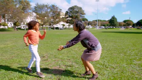 Cheerful-African-American-daughter-running-to-Asian-mom-in-park