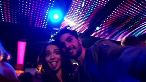 Couple-making-silly-faces-and-posing-for-selfie-in-club