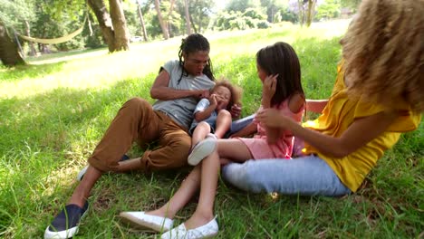 Atemberaubende-afroamerikanischen-Familie-entspannende-unter-einem-Baum-im-Park