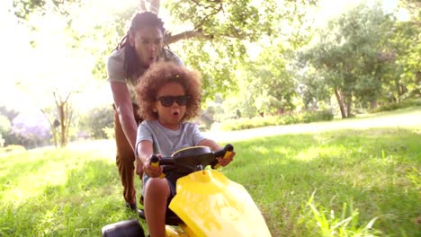 Atractivo-afroamericana-Padre-e-hijo-jugando-con-un-coche-de-pedales