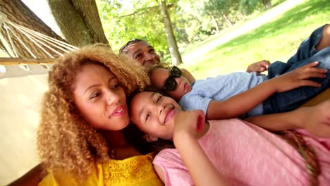 Photogenic-Multi-ethnic-family-relaxing-together-on-a-hammock