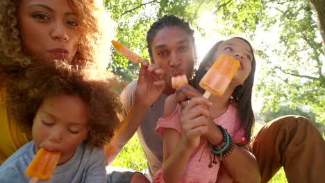 Junge-attraktive-Paar-Essen-Eiscreme-in-der-Sonne-mit-Kindern