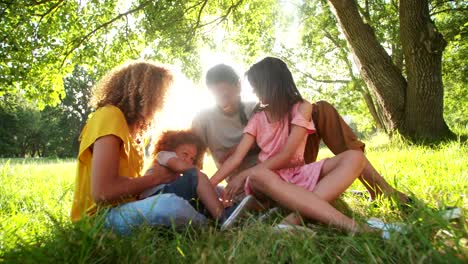 Atemberaubende-afroamerikanischen-Familie-entspannende-unter-einem-Baum-im-Park