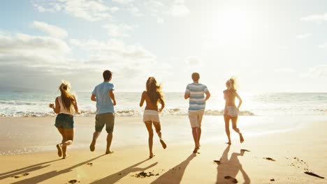 Gruppe-von-Freunden-Spaß-einem-Strandspaziergang-bei-Sonnenuntergang