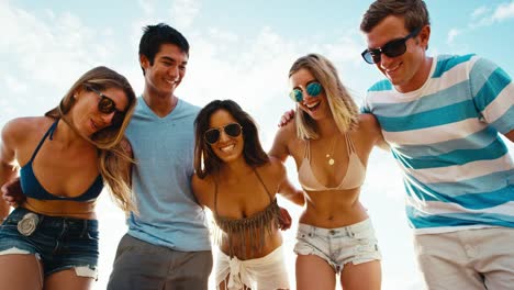 Group-of-friends-hanging-out-on-the-beach-at-sunset