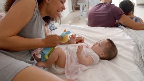 Mutter-spielt-mit-Baby-Tochter-im-Schlafzimmer-zu-Hause