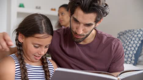 Familia-sentada-en-el-libro-de-lectura-de-dormitorio