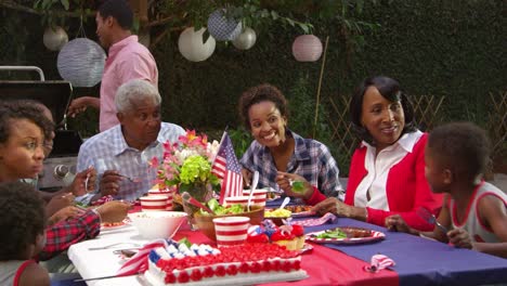 Multi-generation-family-barbecue,-grandson-stands-at-table,-shot-on-R3D