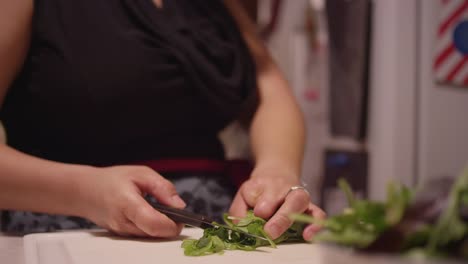 Close-up-of-a-woman-slicing-lettuce-with-a-knife-in-the-kitchen