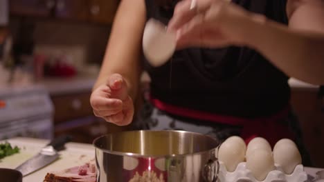 Una-mujer-se-agrieta-los-huevos-en-un-recipiente-en-la-cocina