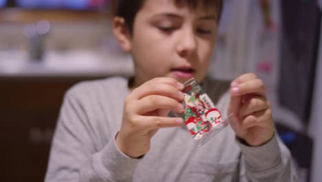 Ein-kleiner-Junge,-der-mit-seinen-Zähnen-einen-Namensschild-aus-einem-Plastikhalter-nimmt