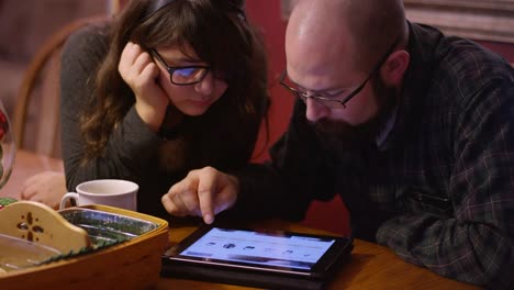 Un-padre-y-una-hija-en-la-mesa-mirando-una-tableta-juntos,-en-línea-de-compras