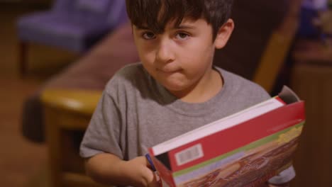 A-little-boy-cutting-open-a-cardboard-box-with-scissors