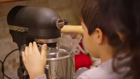 Siblings-using-an-electric-mixer-at-home