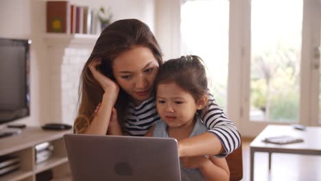 Mutter-und-Tochter-Film-auf-Laptop-zu-Hause-zusammen