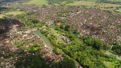 Vista-aérea-en-Bali,-Indonesia:-largo.-una-fila-ordenada-de-estructuras-con-niveles.-techos-en-Pura-Taman-Ayun.