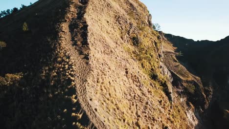 Gruppe-von-Freunden-zu-Fuß-hinunter-den-Hügel-und-Pan-bis-Reveal-Mount-Batur-Peak-und-Vulkankrater-4-K