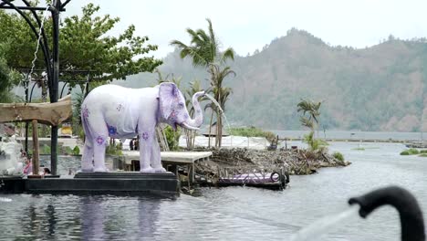 Agua-que-fluye-en-la-piscina-de-aguas-termales-de-tronco-de-estatuas-de-elefantes-Bali