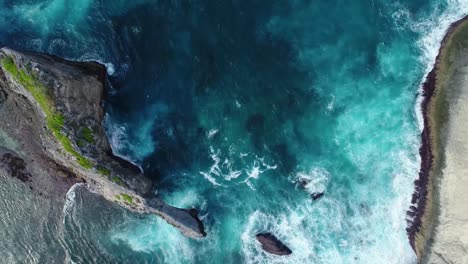 Vista-aérea-de-cámara-drone-4k.-Rocas-en-una-laguna-de-mar-azul-con-oleaje.