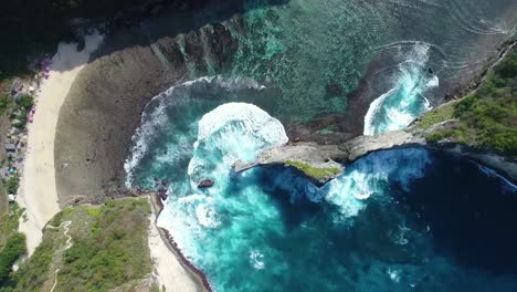 Vista-aérea-de-cámara-drone-4k.-Rocas-en-una-laguna-de-mar-azul-con-oleaje.