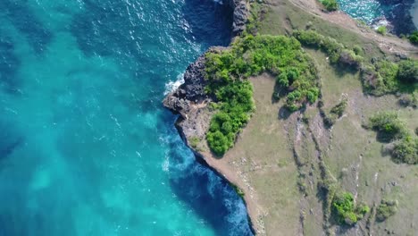 Cliff-mit-Wellen,-die-gegen-eine-felsige-Ufer,-Nusa-Penida,-Indonesien.