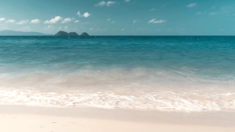 Wellen-am-Strand,-die-Inseln-am-Horizont