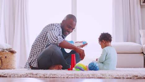 Junge-schwarze-Vater-mit-Sohn-in-ihrem-Wohnzimmer-spielen