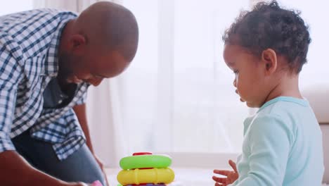 Padre-negro-joven-arrodillado-y-jugando-con-su-hijo