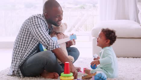 Joven-padre-negro-cantando-a-su-hijo-llorando-en-la-sala-de-estar