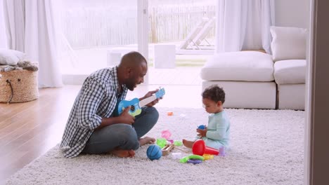 Joven-padre-negro-cantando-a-su-hijo-en-la-sala-de-estar