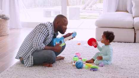 Junge-schwarze-Vater-mit-seinem-Sohn-im-Wohnzimmer-spielen