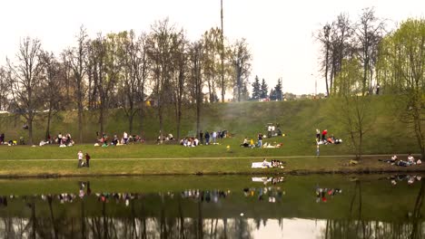 a-lot-of-people-on-a-spring-picnic-on-the-shore-of-the-city-pond,