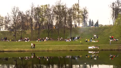 eine-Menge-Leute-auf-ein-frühlingspicknick-am-Ufer-des-Teiches-Stadt