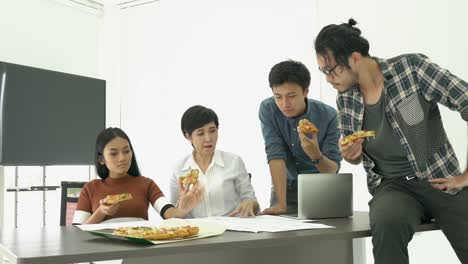 Gente-de-negocios-comer-pizza-es-tiempo-de-descanso-y-reunión-equipo-junto-para-proyecto-de-éxito.-Concepto-de-trabajo-en-equipo,-relax,-trabajo-creativo-y-compartir-la-idea.