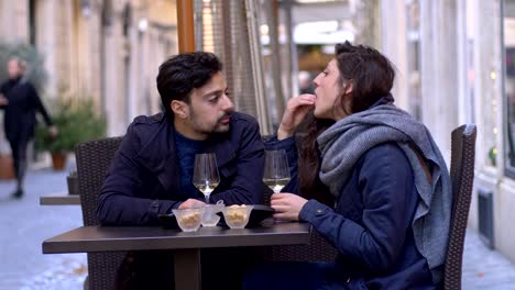 Young-couple-sitting-at-the-restaurant-smiling,chatting,toasting--outdoor