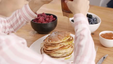 Teil-Frau-essen-Pfannkuchen-in-Küche