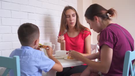 Familie-essen-Frühstück-in-der-Küche-zusammen