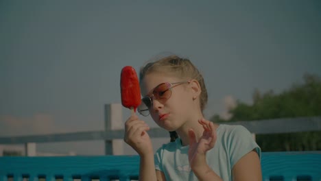 Happy-child-eating-delicious-fruit-popsicle-outdoors