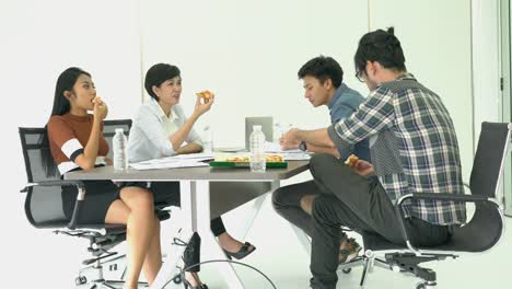 Business-people-eating-pizza-is-break-time-and-meeting-team-together-for-success-project.-Concept-of-teamwork,-relax,-creative-working-and-sharing-idea.