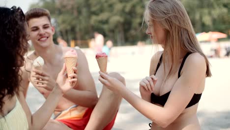 Young-people-enjoying-a-day-at-the-lake-and-eating-ice-creams.