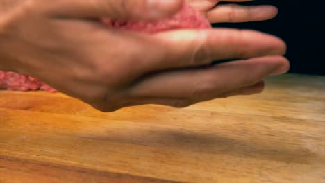 slow-motion-tattooed-chef-hands-forming-hamburger-patties-on-wood-butcher-block